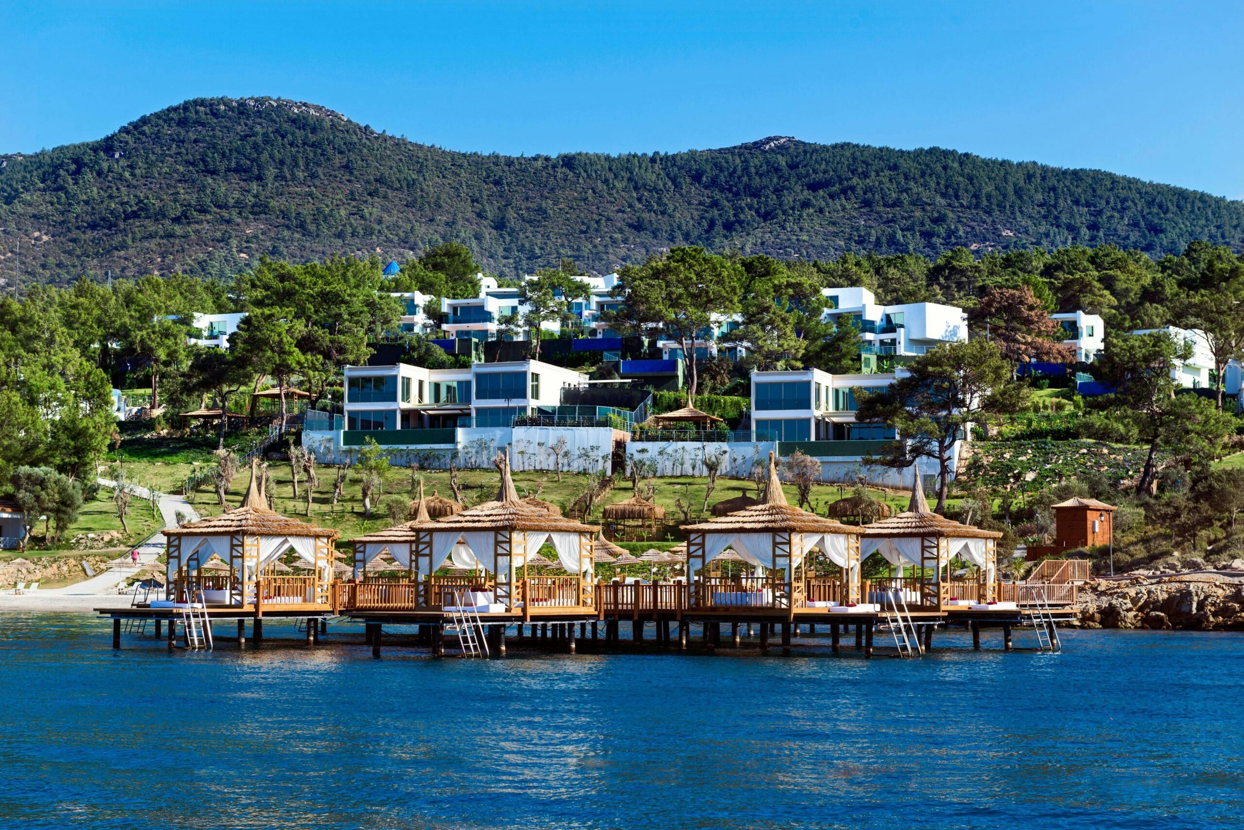 Beautiful seaside resort featuring cabanas and villas by the lush hillside.