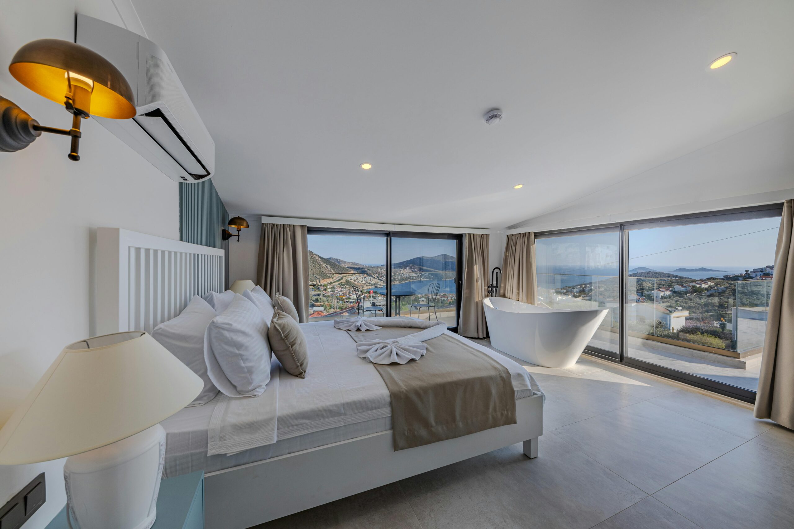 Spacious bedroom with a stunning view of the ocean, accented by contemporary design and luxury furniture.