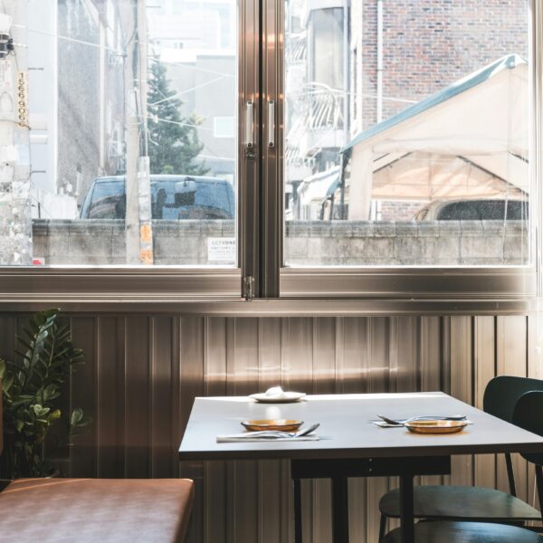 A stylish restaurant interior with a glass window showcasing an urban cityscape in Seoul. Perfect for hospitality themes.