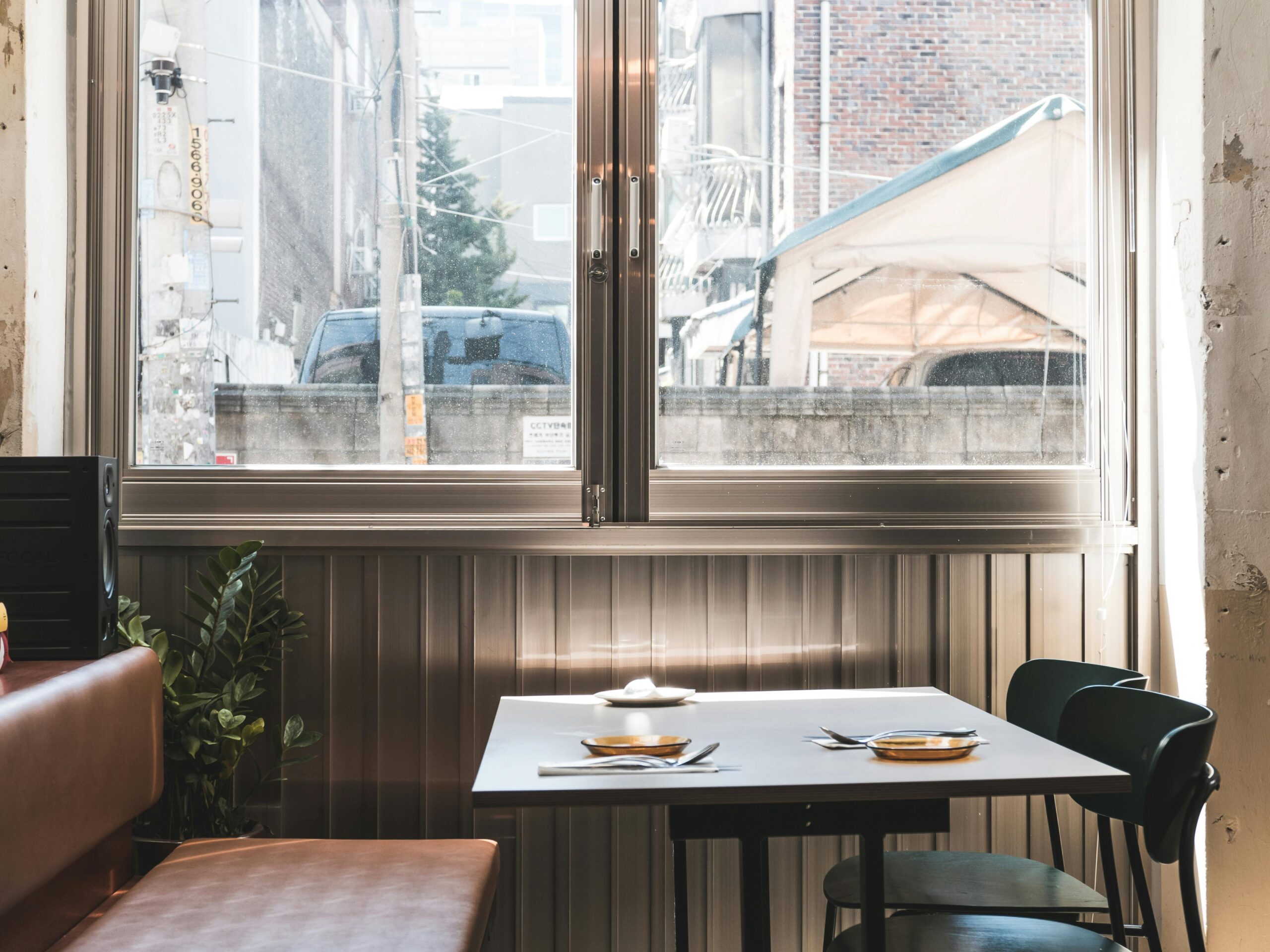 A stylish restaurant interior with a glass window showcasing an urban cityscape in Seoul. Perfect for hospitality themes.